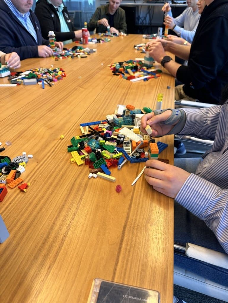 שולחן חדר ישיבות מכוסה בלבני LEGO® צבעוניות, מפגש בעיצומו